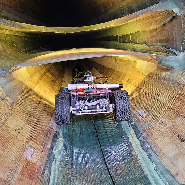 Ein Roboter auf Rädern, der ein Rotorblatt von innen inspiziert