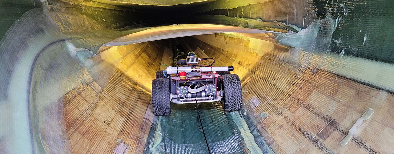 Ein Roboter auf Rädern, der ein Rotorblatt von innen inspiziert