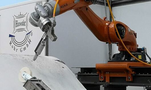 Ein Roboter mit aufgesetzten Wasserstrahlschneider kann Bereiche des Rotorblattes aus verschiedenen Materialien exakt trennen.
